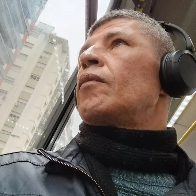 Alex wearing headphones and looking out a window.